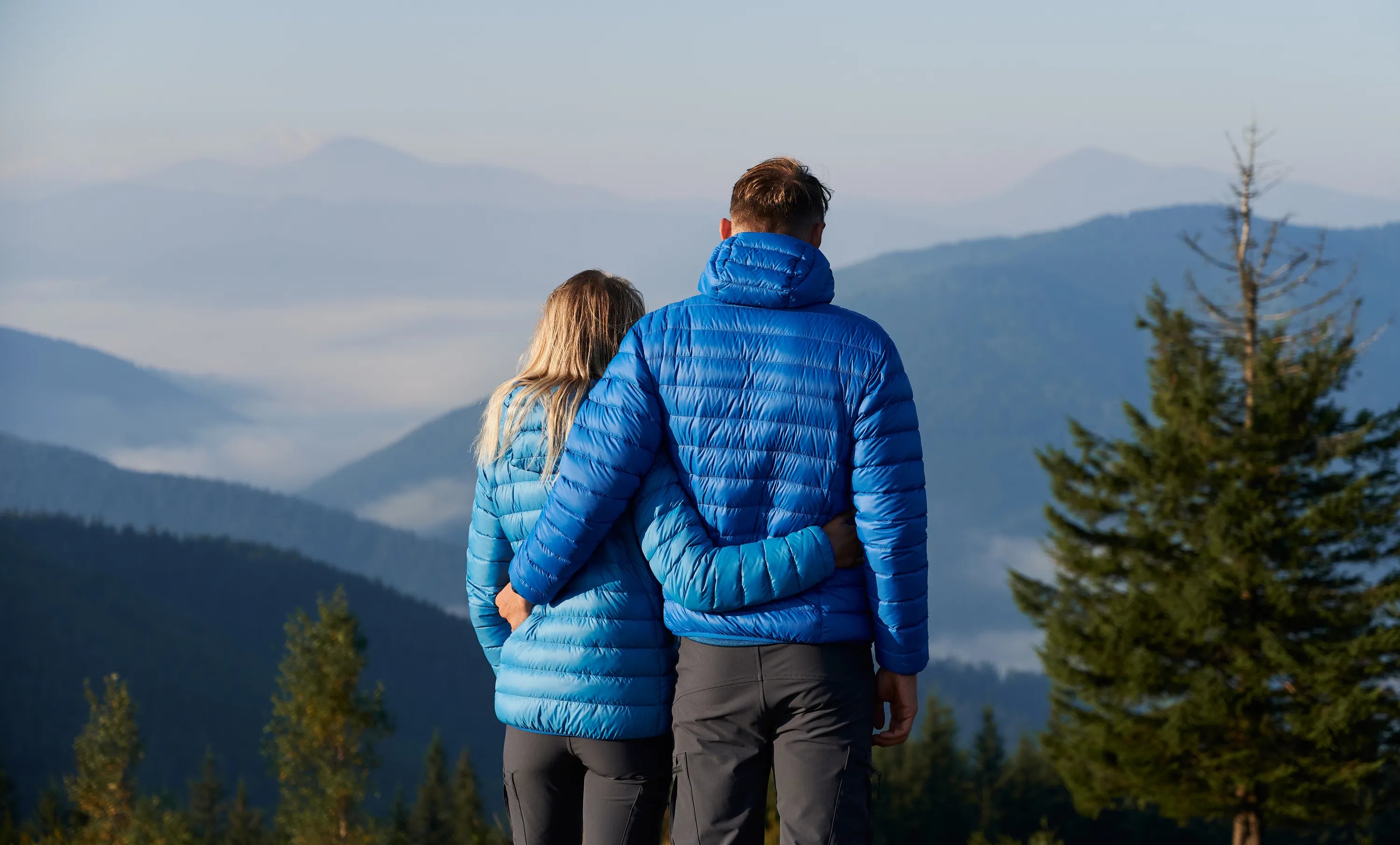 A couple looking out over misty mountains